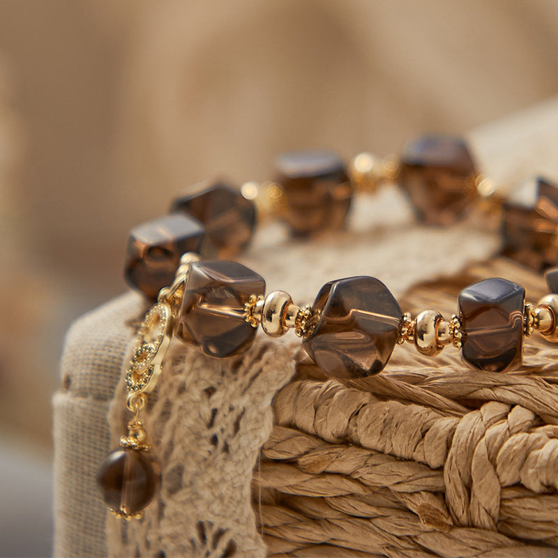 Natural Smoky Quartz crystal bracelet displayed in a flat lay jewelry styling arrangement