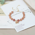 Natural Orange Moonstone Bell Bracelet with polished crystal beads and delicate charm for women.