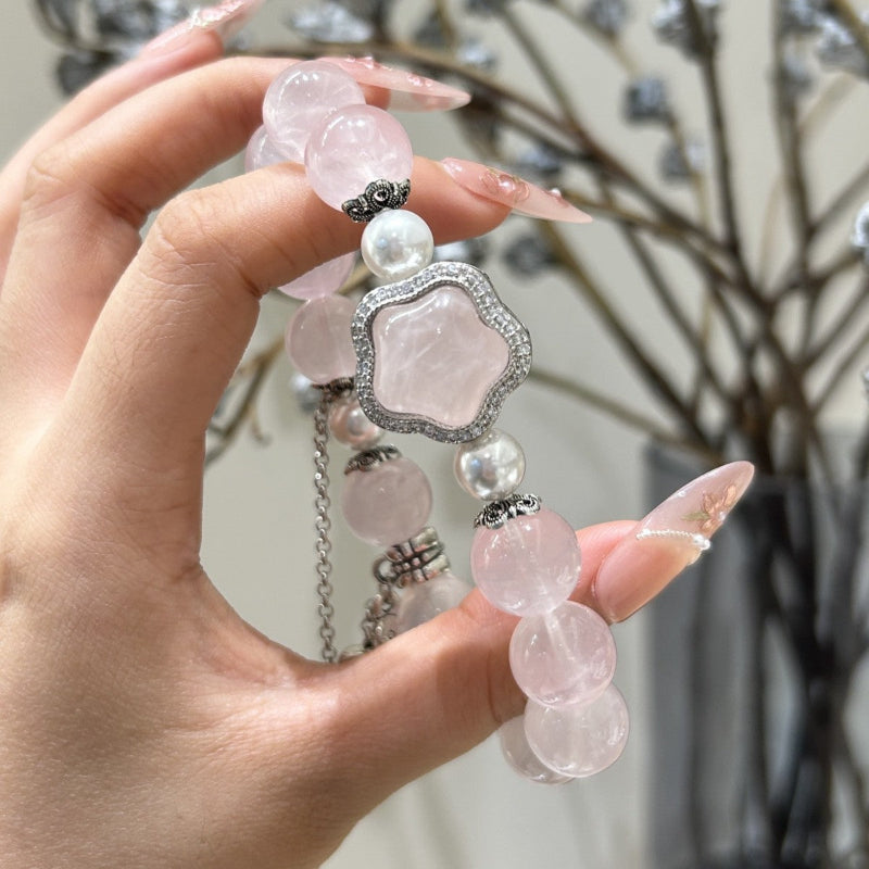 Woman wearing a Rose Quartz and pearl bracelet with peach blossom charm for elegant everyday style