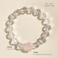Close-up of a carved Rose Quartz fox charm surrounded by natural Clear Quartz gemstone beads