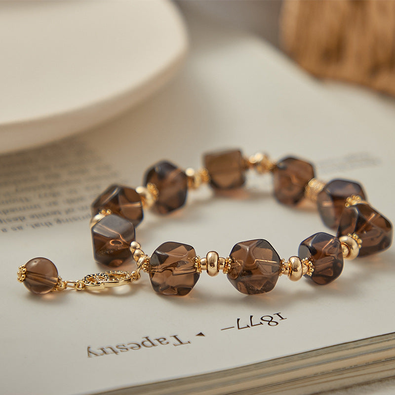 Woman wearing a faceted Smoky Quartz bracelet with warm brown crystal tones and minimalist style